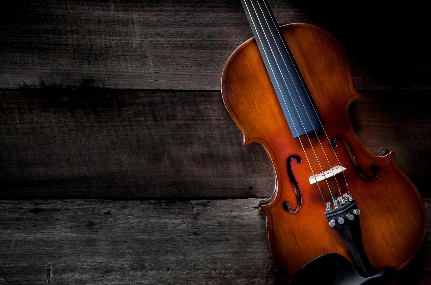 el violín en la mesa, cerca del violín en el suelo de madera foto