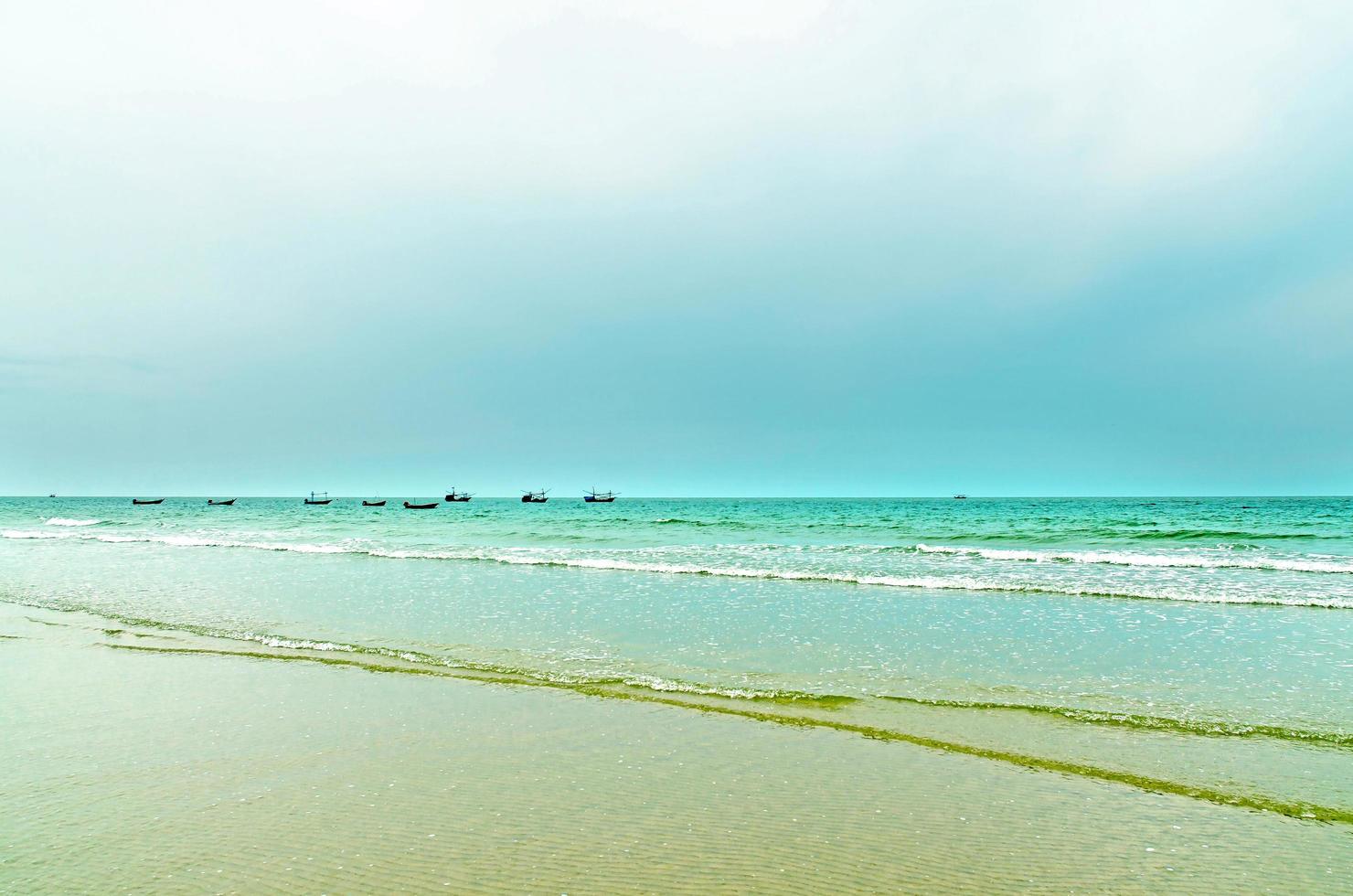 The view of the sand beach and sea wave with rock and reef on morning photo