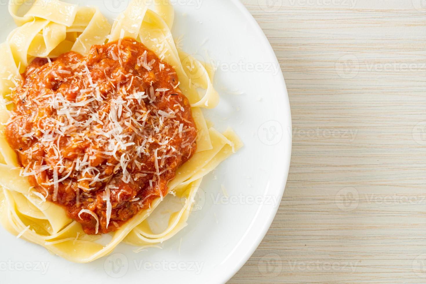 fettuccine de cerdo a la boloñesa con queso parmesano foto