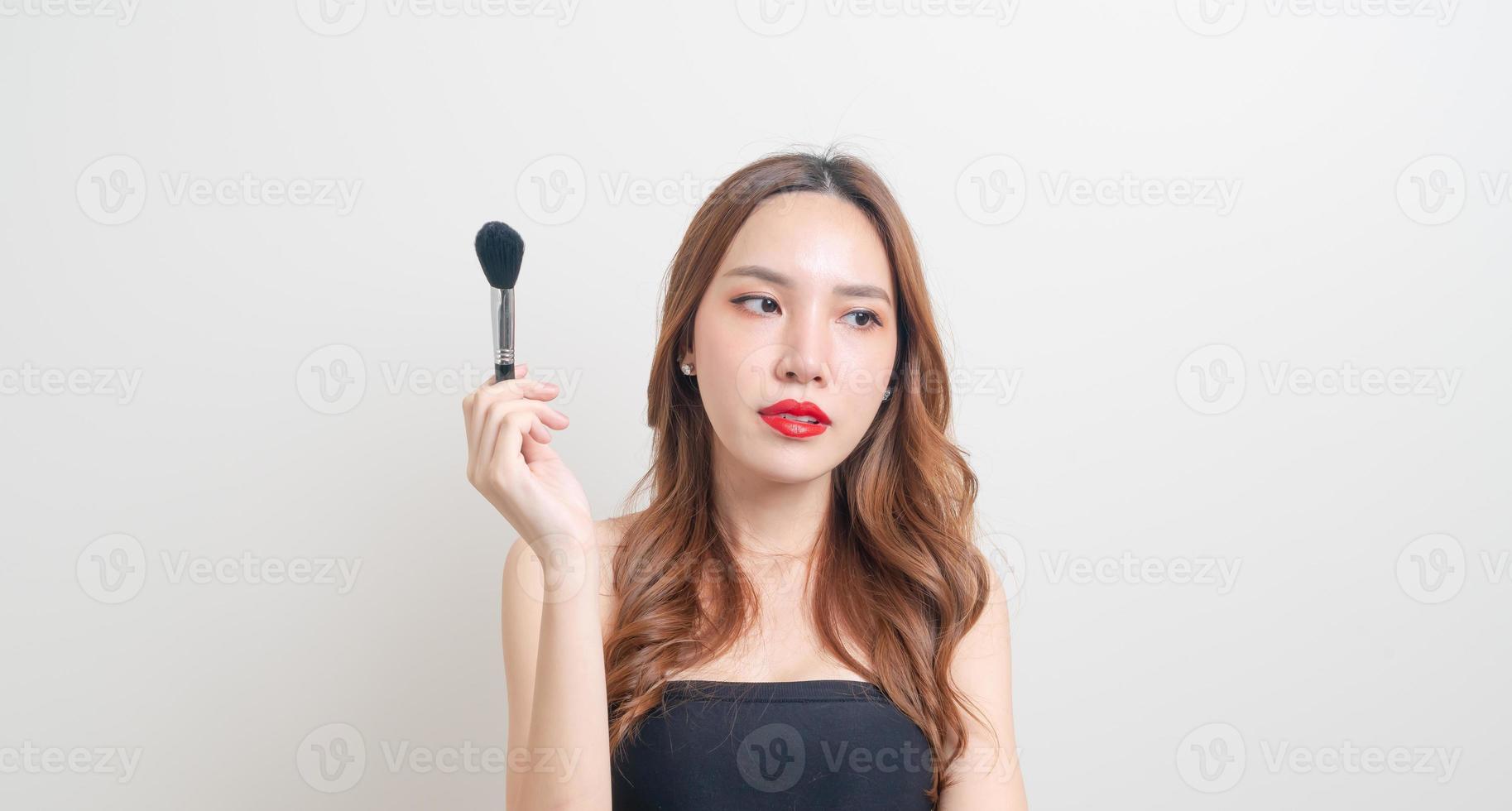Retrato de mujer hermosa con pincel de maquillaje foto