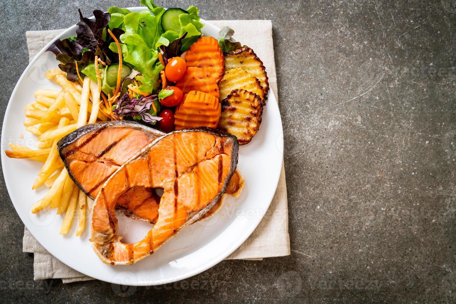 Grilled salmon steak fillet with vegetable and french fries photo