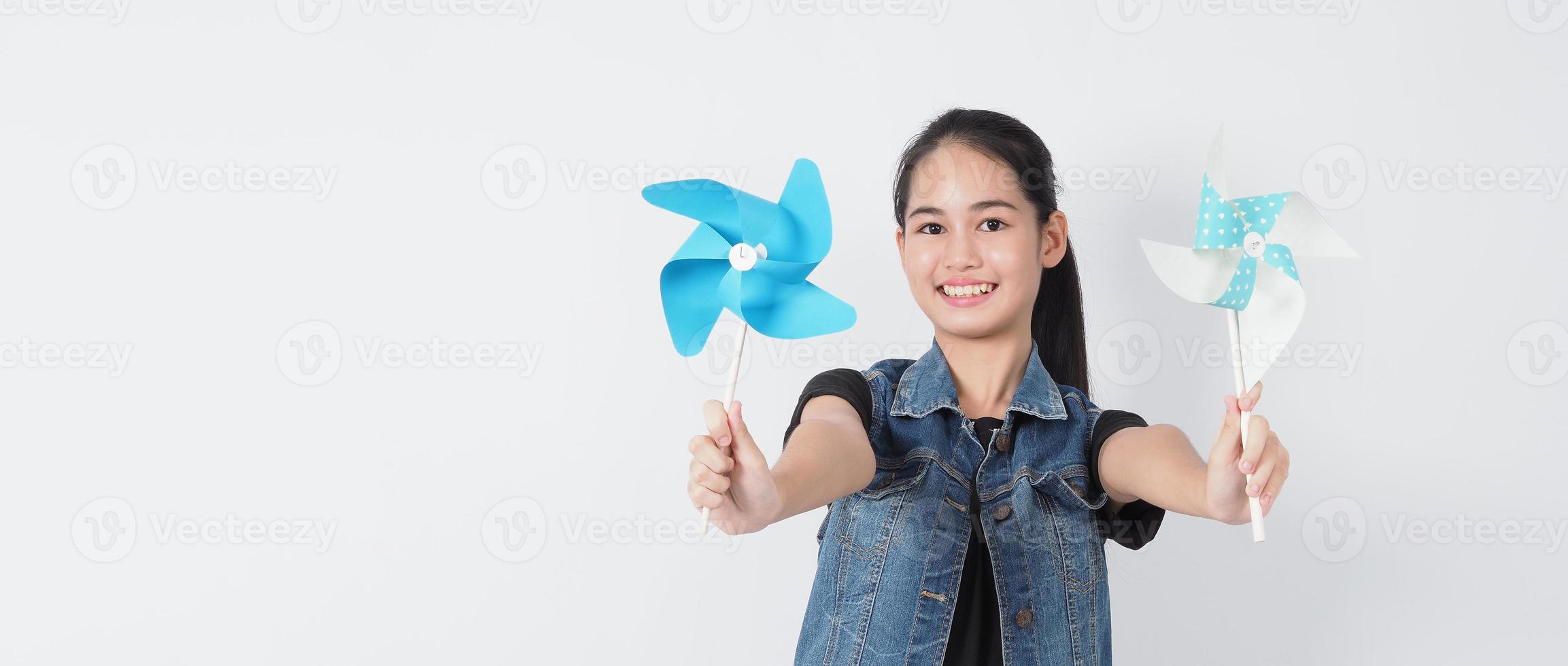 Teenage woman and paper windmill toys photo