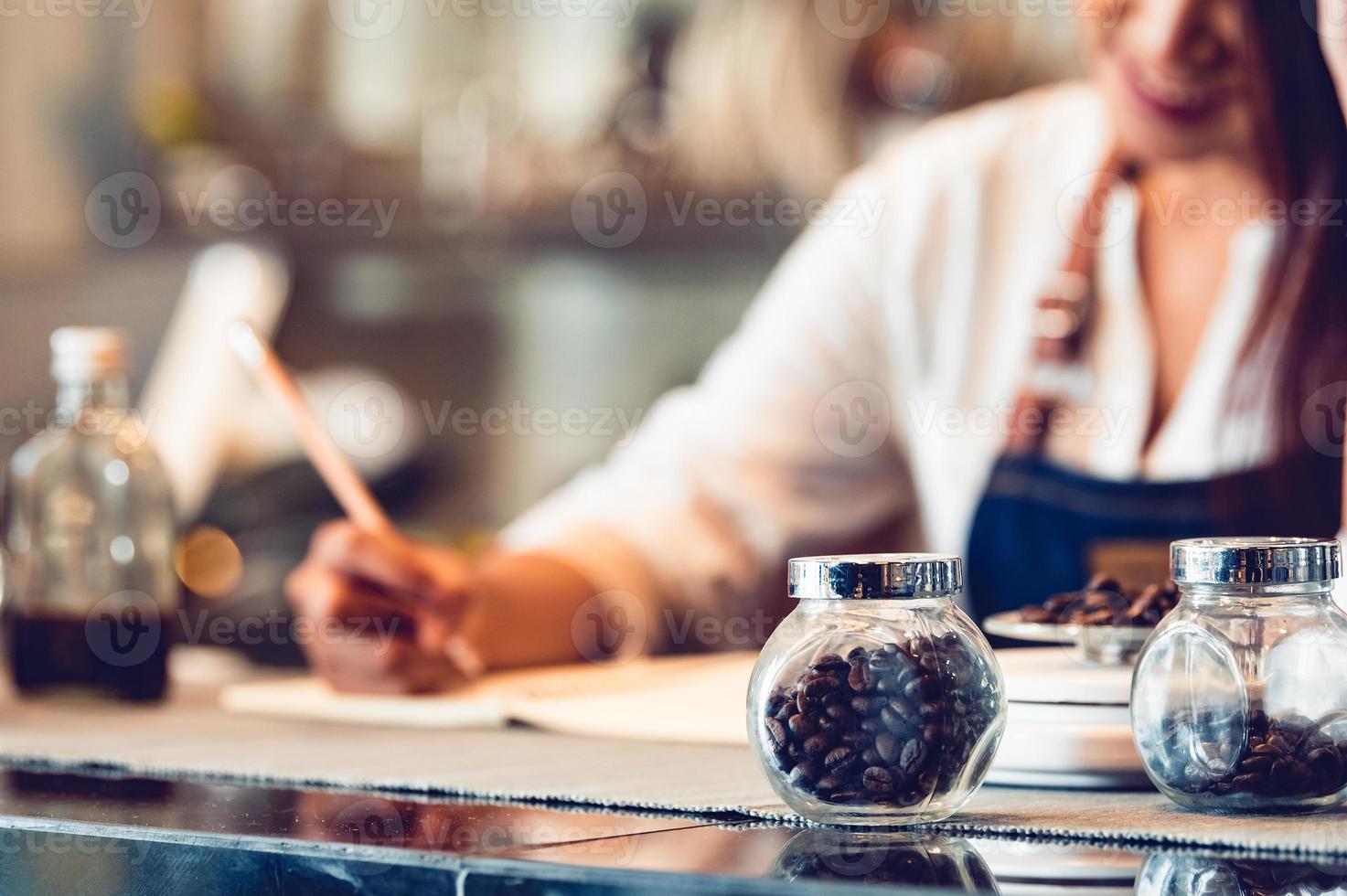 Primer plano de una botella de café en grano y feliz foto