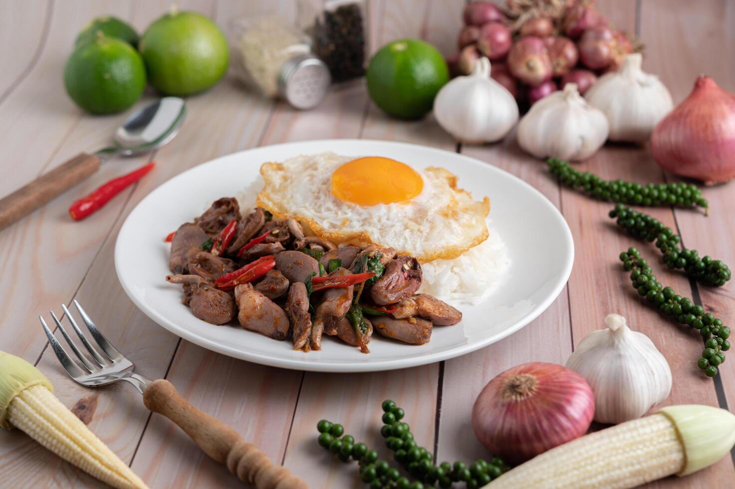 Arroz frito con albahaca sagrada con corazón de pollo y huevo frito foto