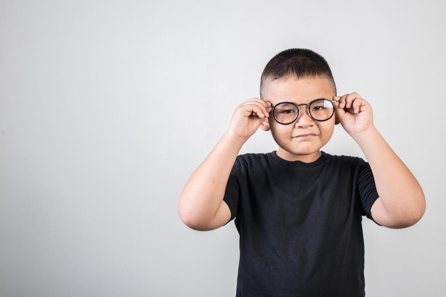 Funny boy genius wearing glasses in studio shot photo