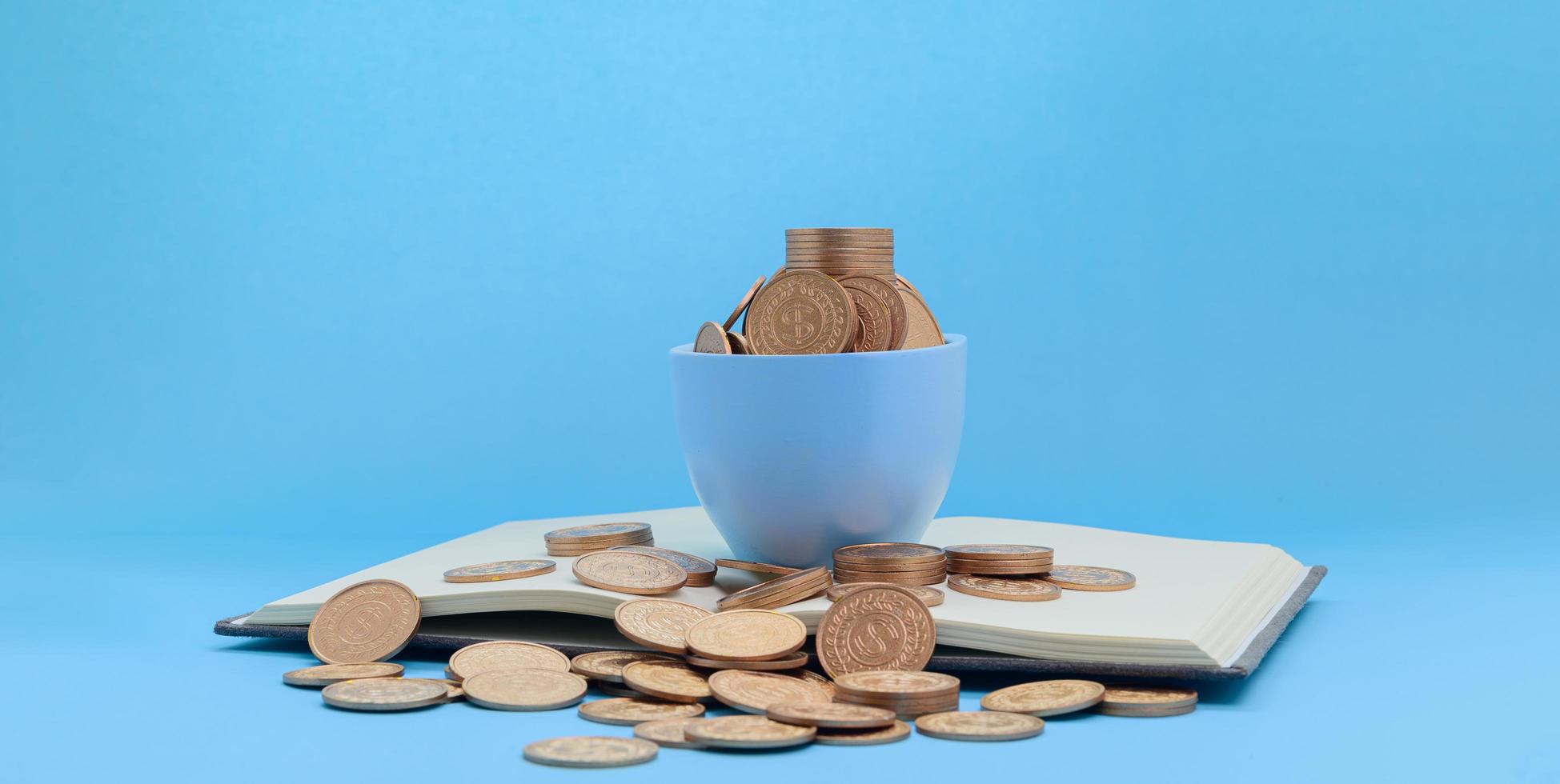 monedas en una taza y un libro foto