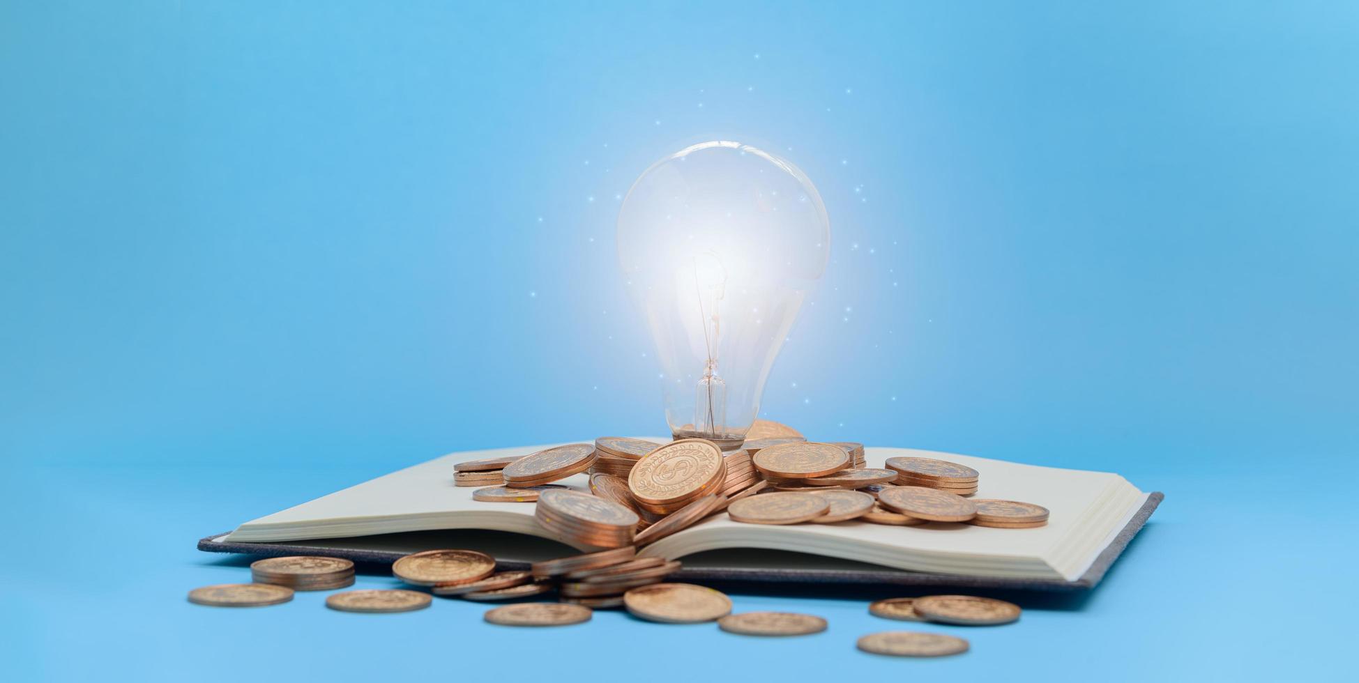 Lightbulb and coins on a book photo