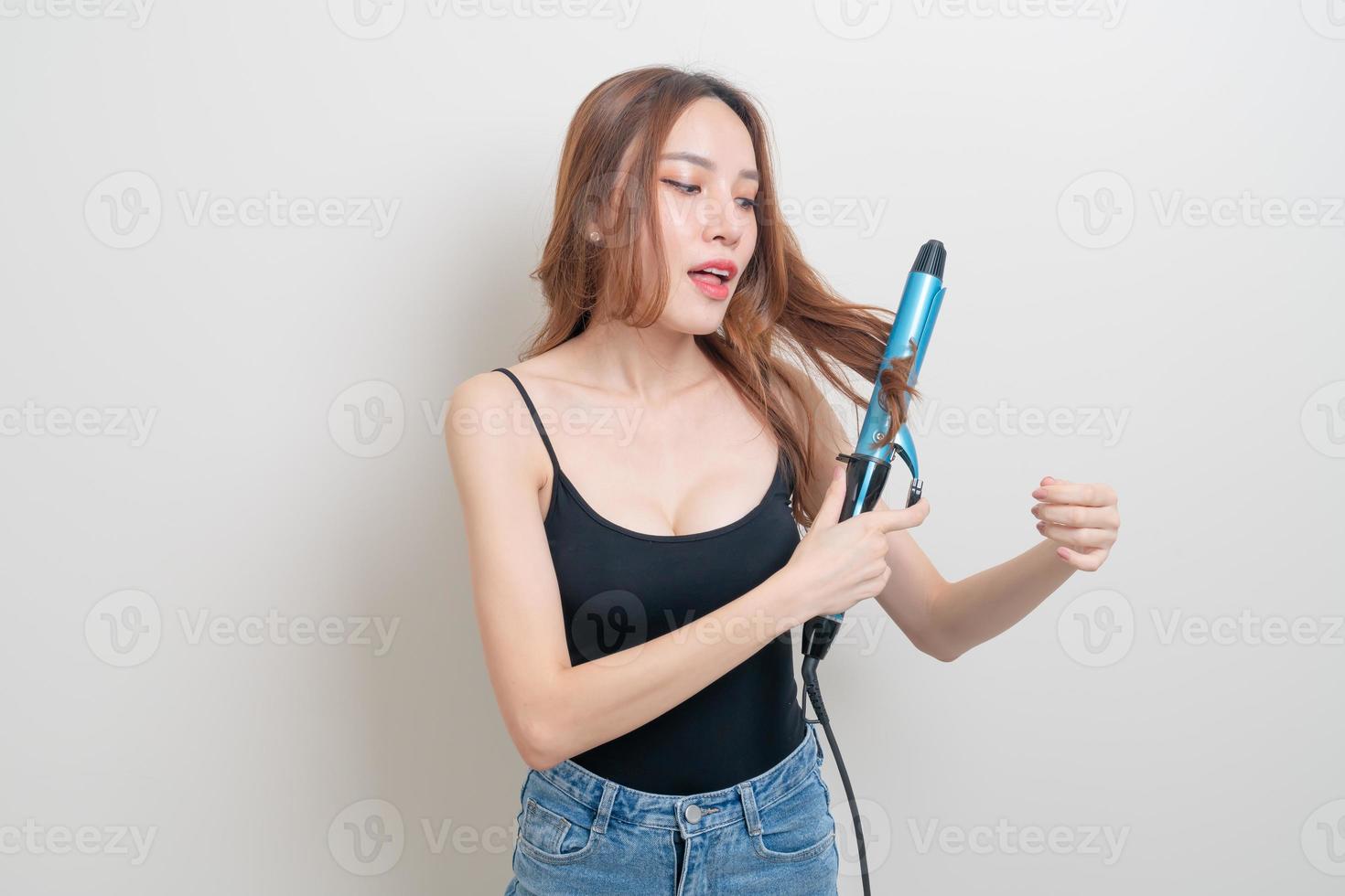 Retrato hermosa mujer asiática con rizador de pelo o rizador foto