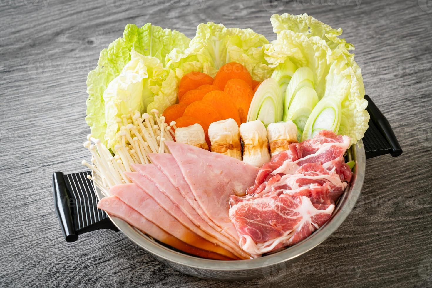 sukiyaki o shabu sopa negra de olla caliente con carne cruda y verdura foto