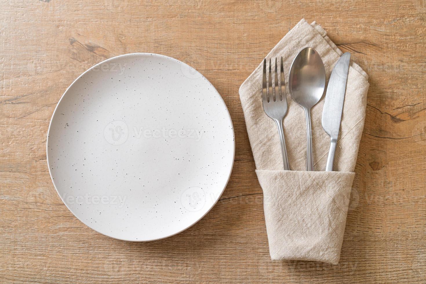 Empty plate or dish with knife, fork and spoon photo