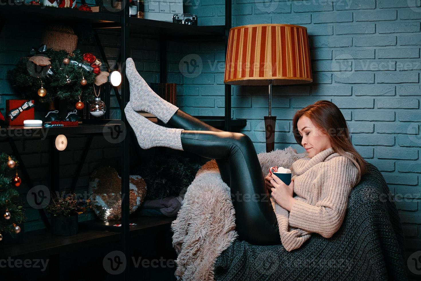 Woman with cup of cocoa sitting on chair photo