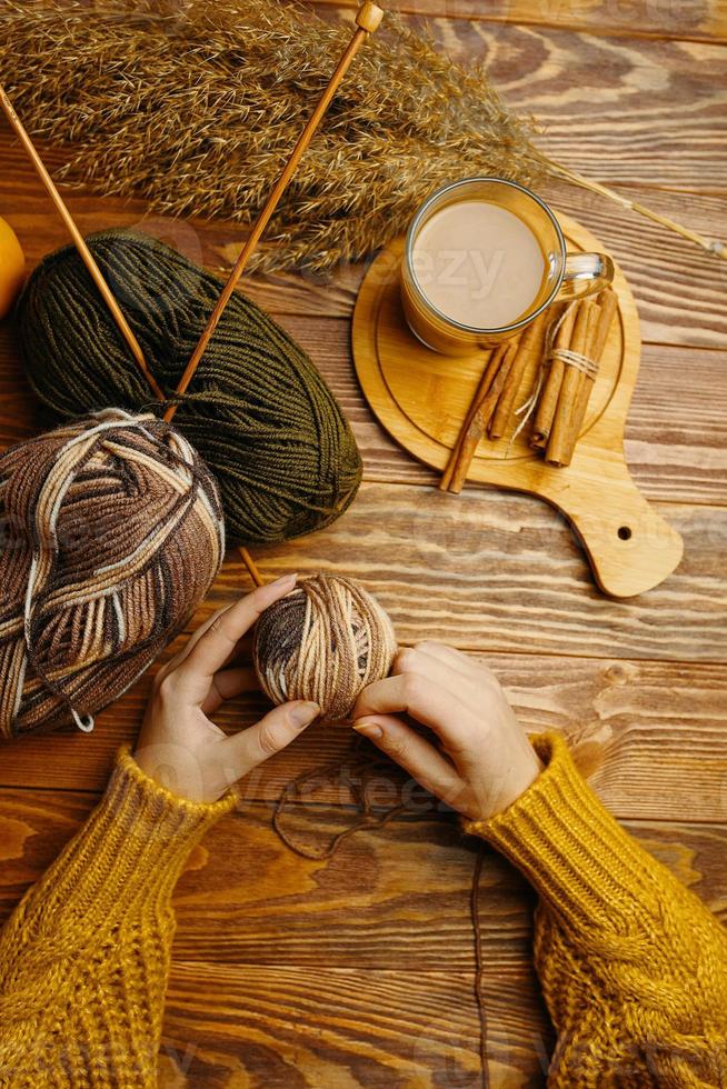 Women's hands with ball of yarn, coffee and cane photo