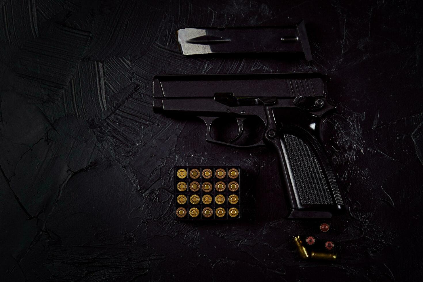 Flat lay of cartridges and gun on concrete background photo