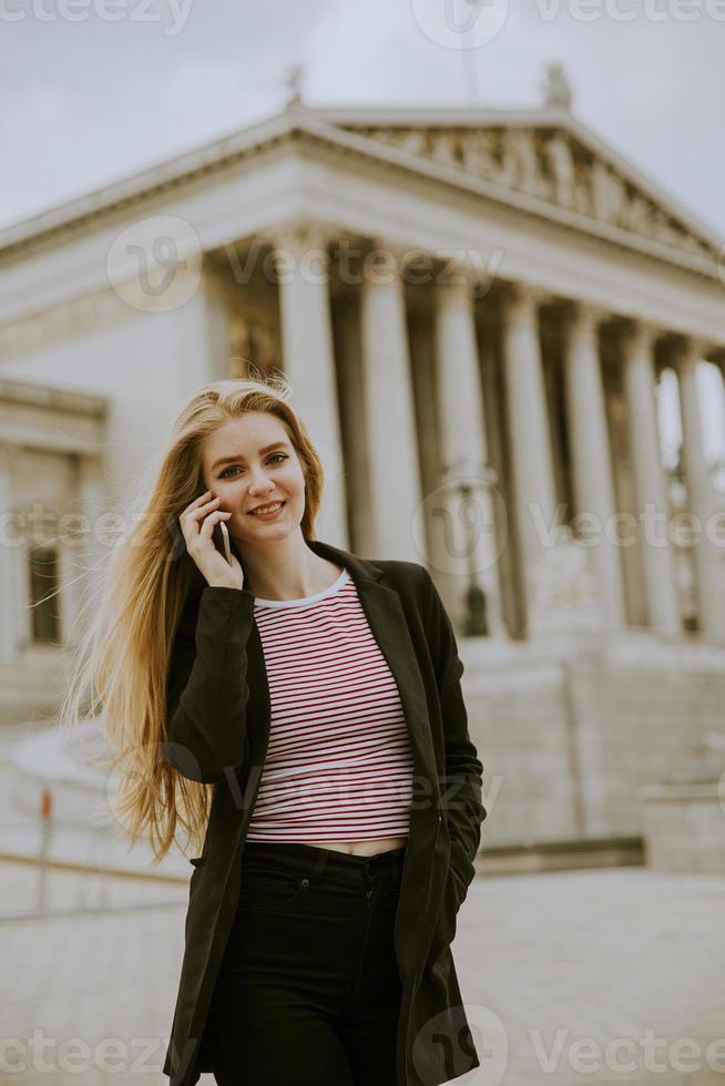 hermosa mujer sonriente con teléfono móvil y caminar foto