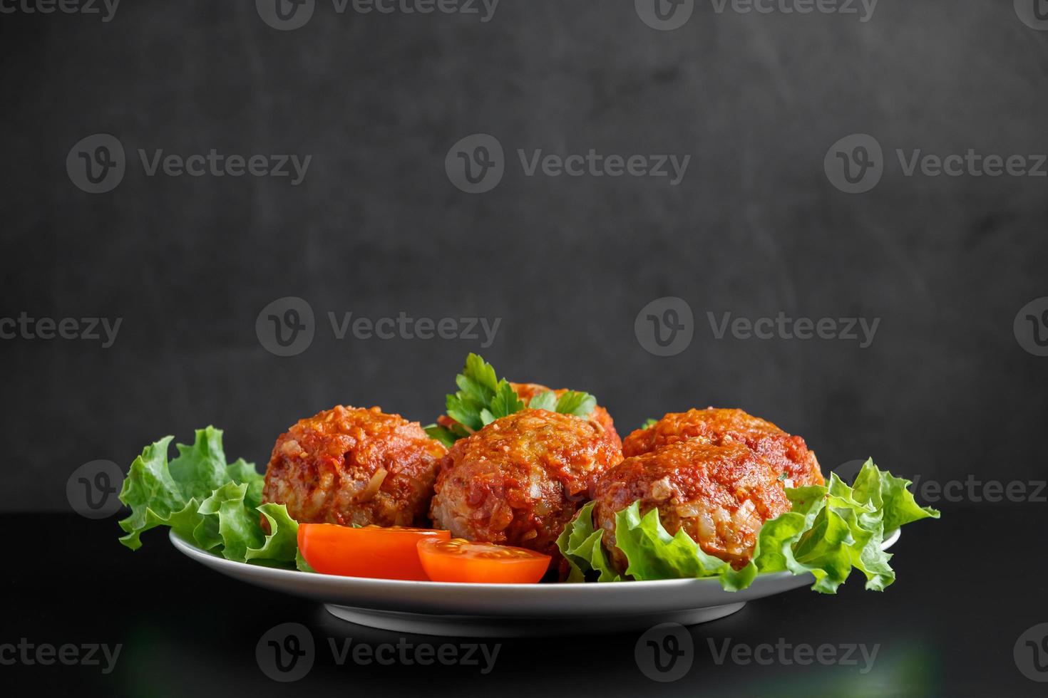 Meat balls in tomato sauce on a black background. photo