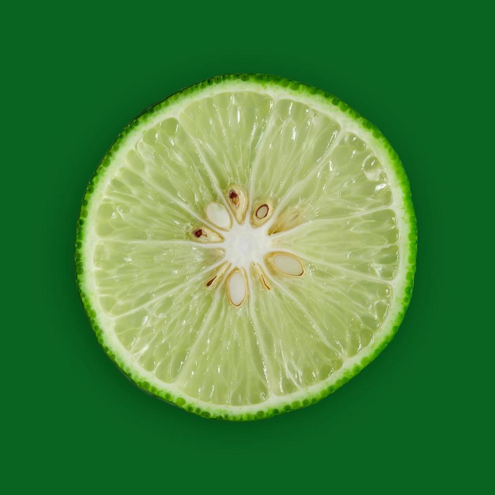 Lemon and lime slice and fresh citrus fruit on green background. photo
