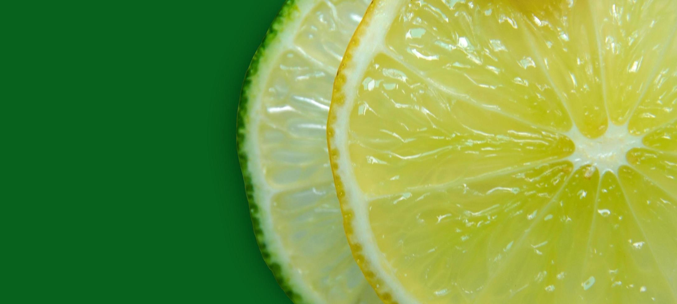 Lemon and lime slice and fresh citrus fruit on green background. photo