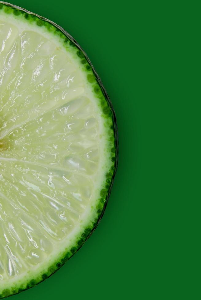 Lemon and lime slice and fresh citrus fruit on green background. photo