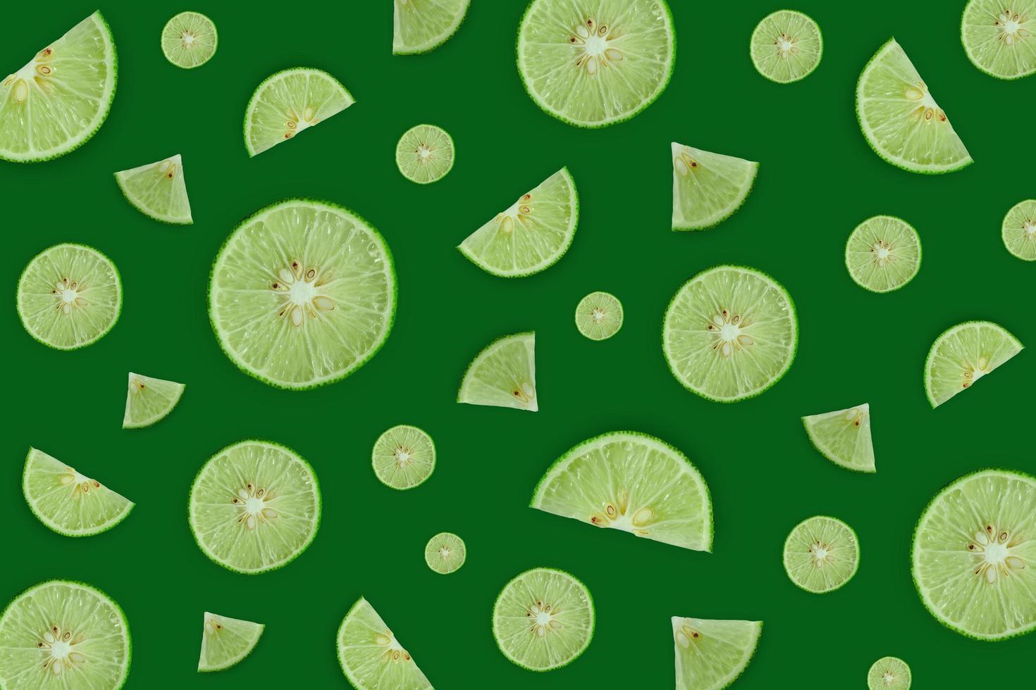 Lemon and lime slice and fresh citrus fruit on green background. photo