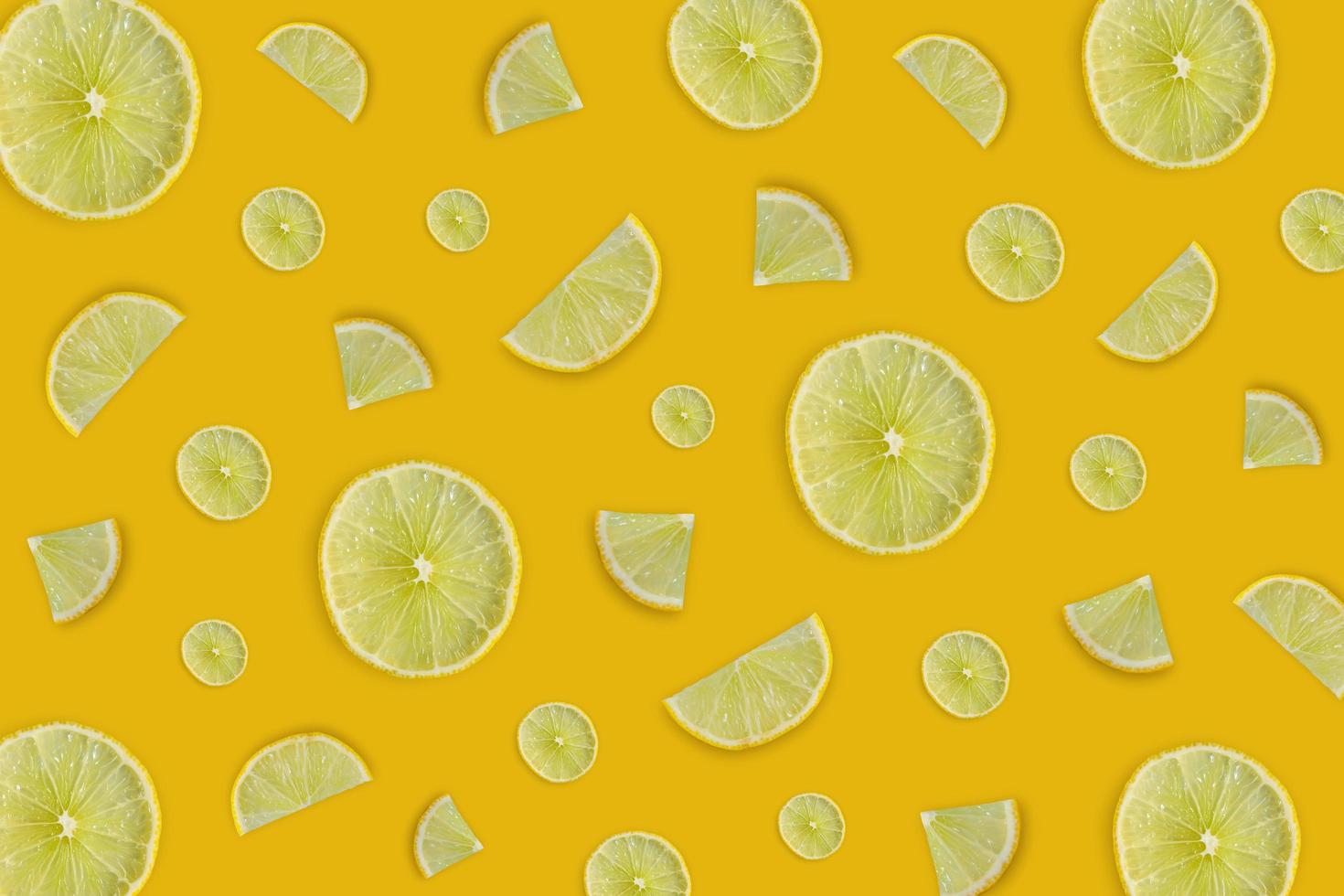 Lemon and lime slice and fresh citrus fruit on yellow background. photo