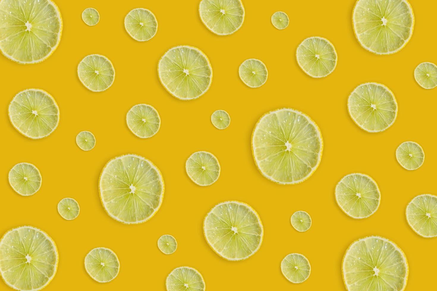Lemon and lime slice and fresh citrus fruit on yellow background. photo