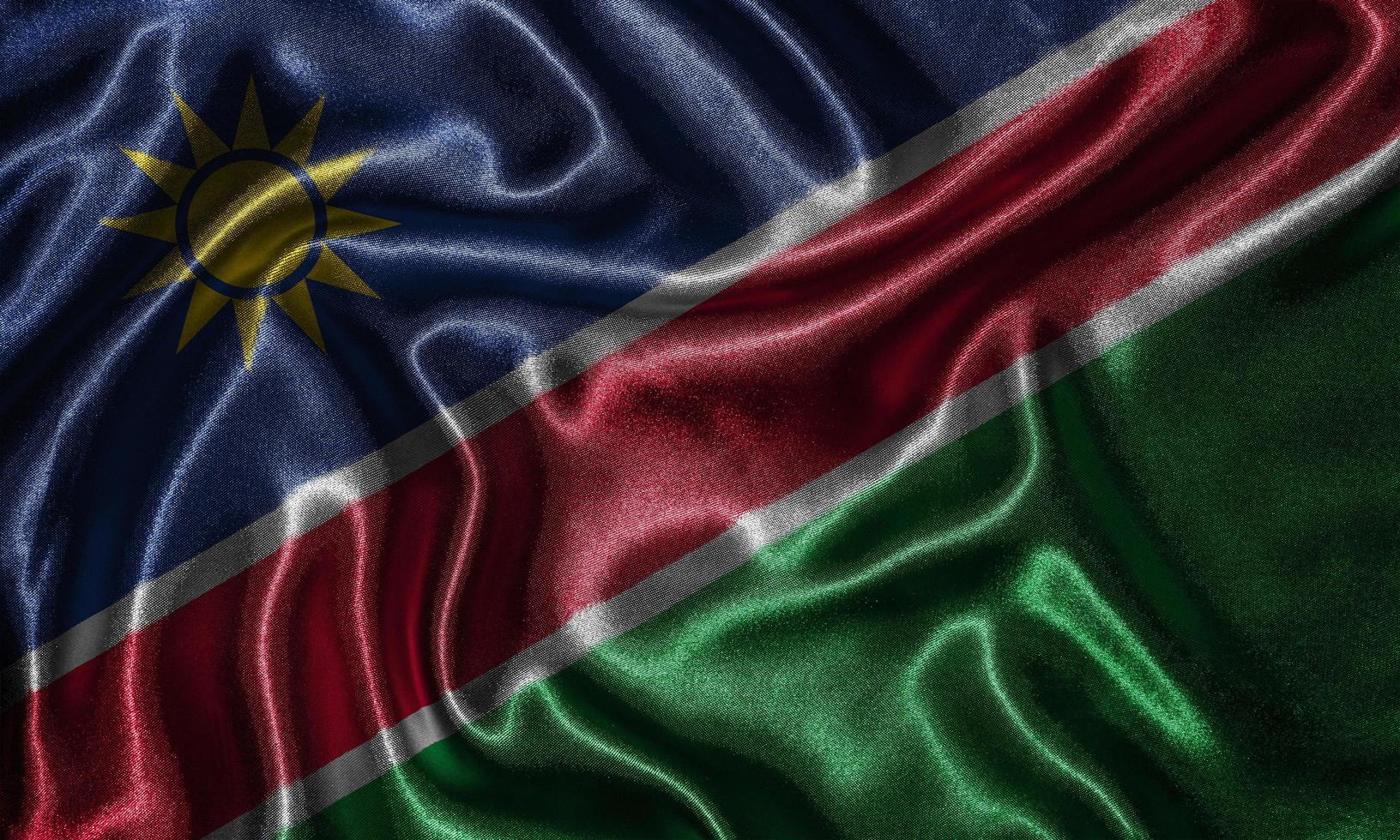 papel tapiz de la bandera de namibia y bandera ondeando por tela. foto