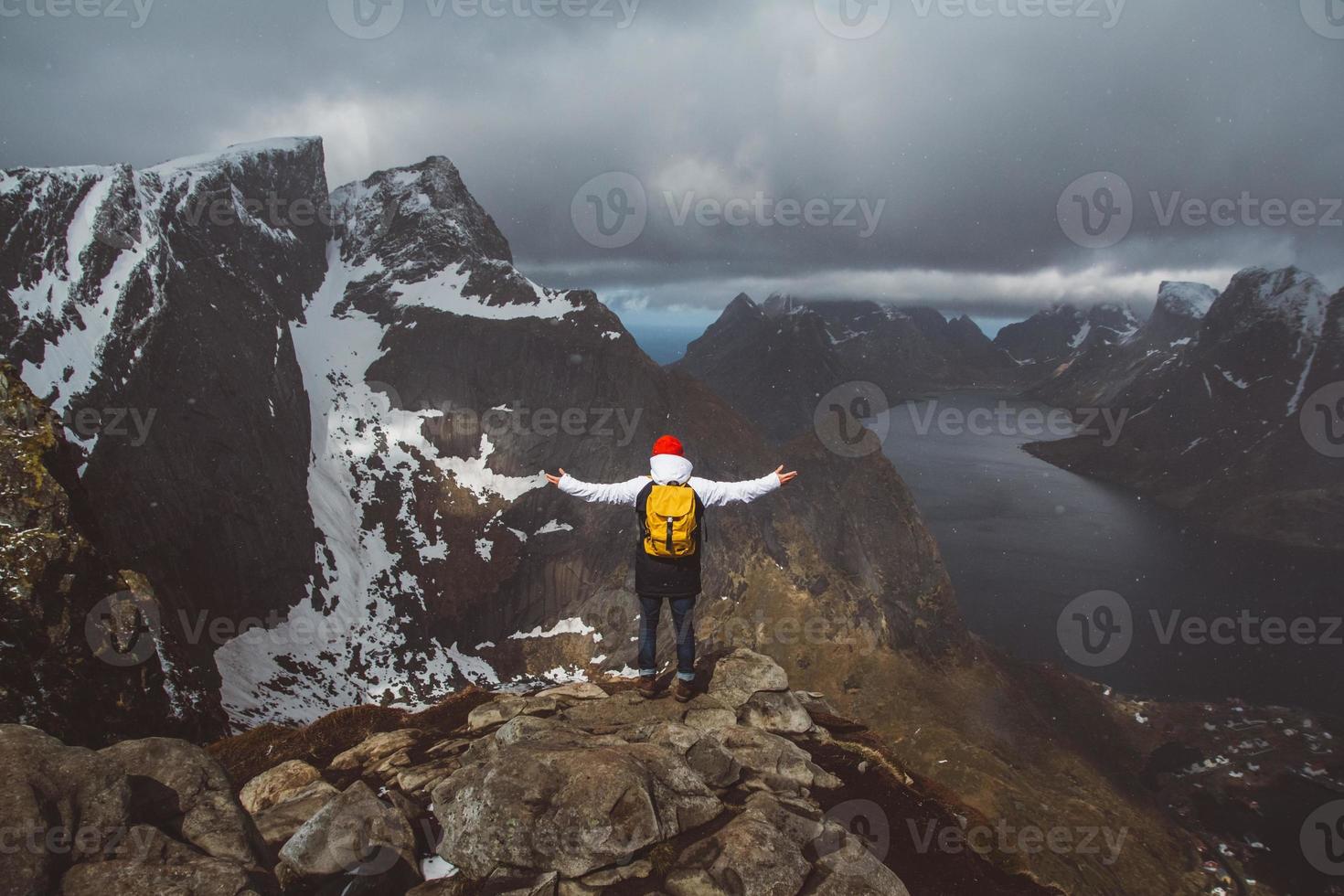 man with a backpack standing on background of mountains and sea photo