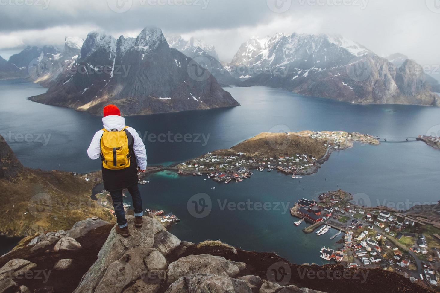 Hombre con una mochila de pie en el fondo de las montañas y el mar foto