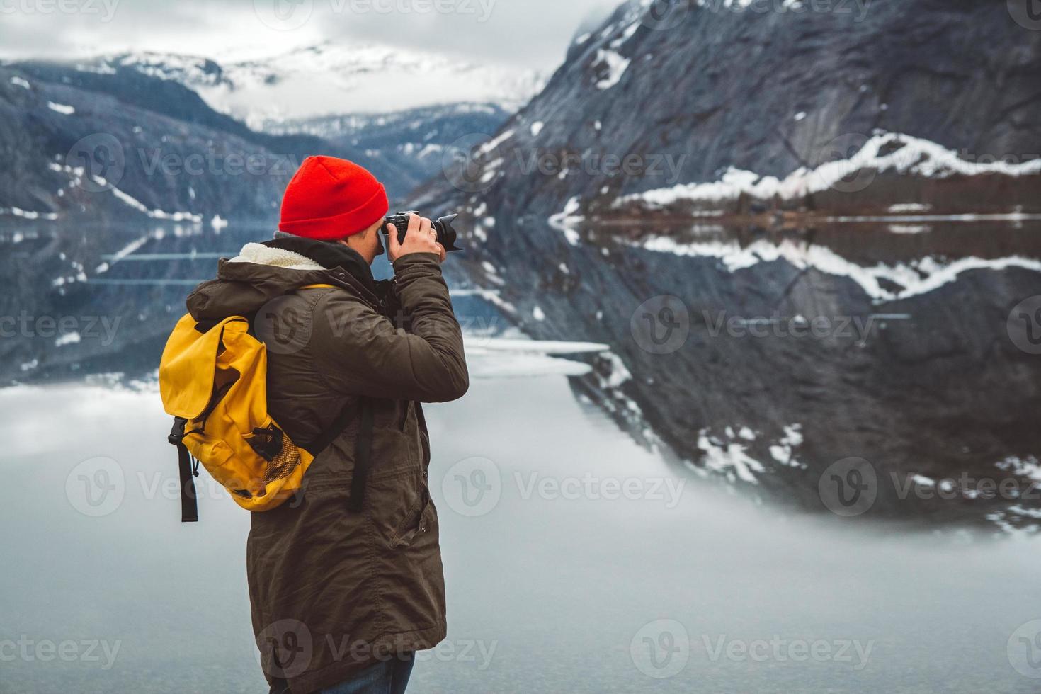 Hombre de pie sobre el fondo de las montañas y el lago hace una foto