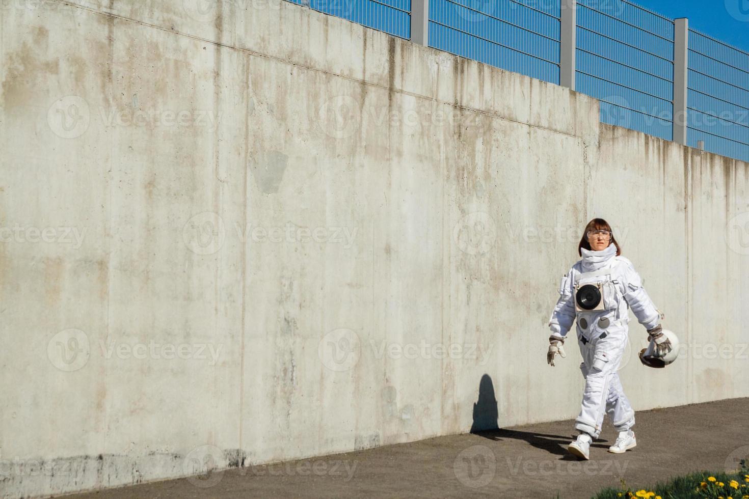 Mujer astronauta sin casco en el fondo de una pared gris foto