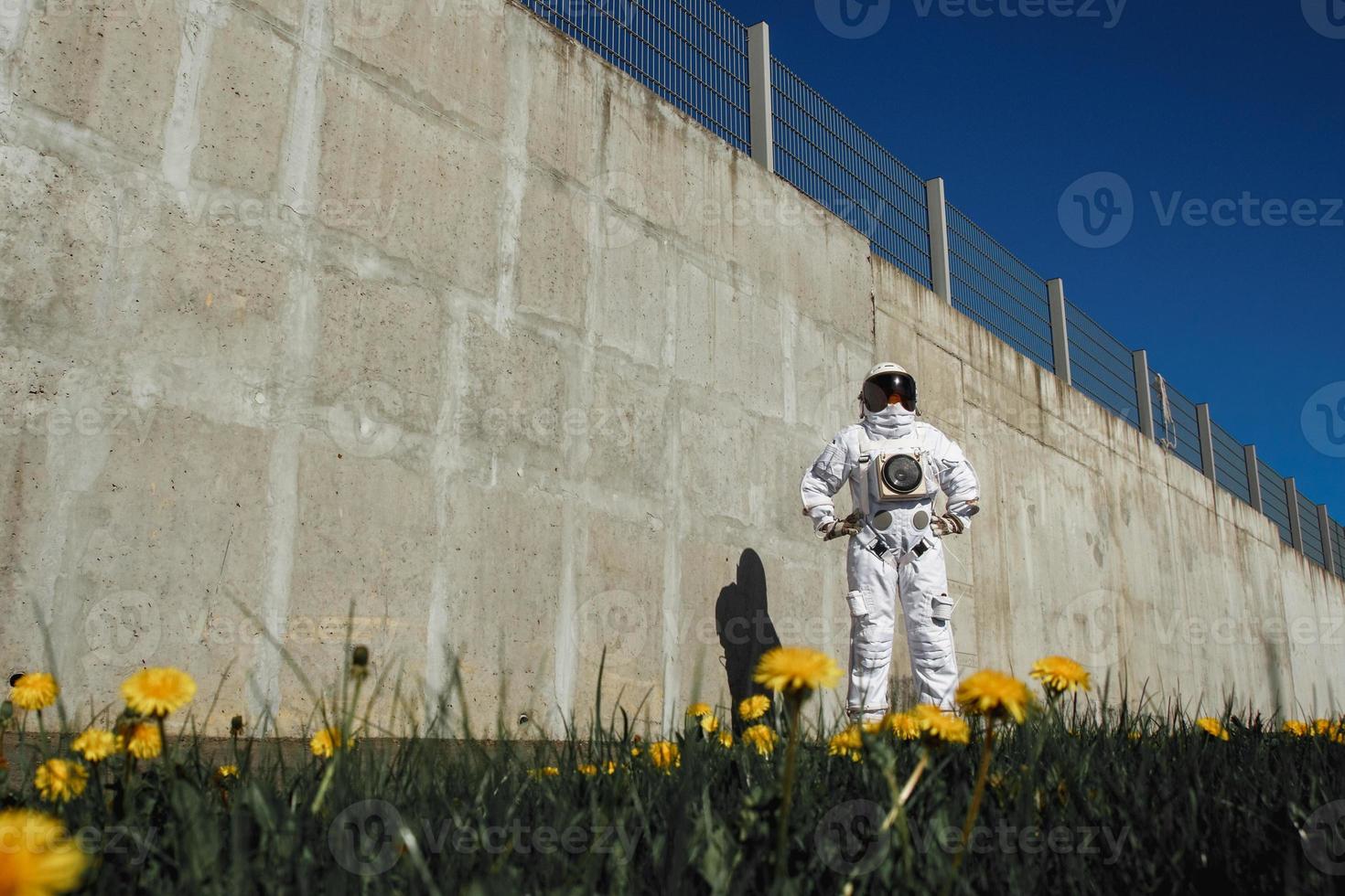 Astronauta futurista en un casco contra paredes grises foto