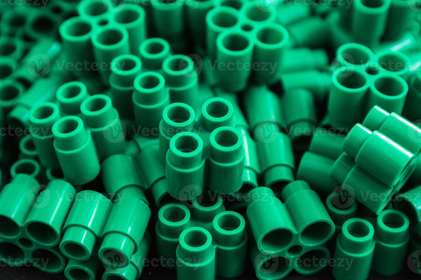 Plastic bricks of green color and details of toys. Green background photo