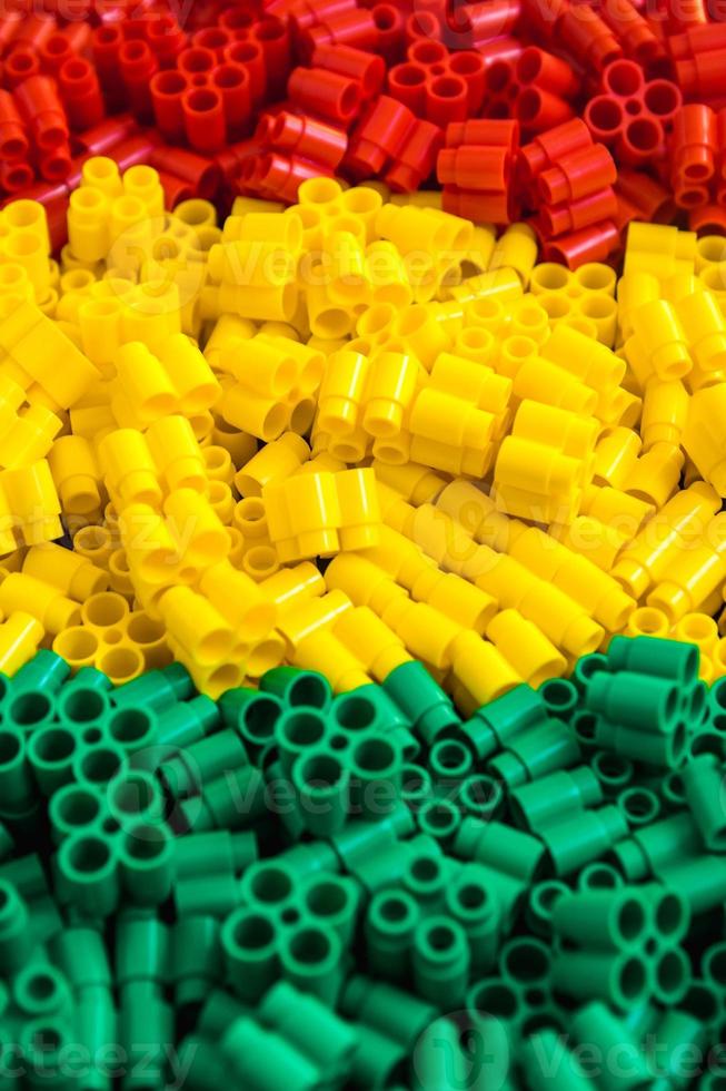 ladrillos de plástico de color rojo, amarillo y verde. detalles de juguetes. de cerca. foto