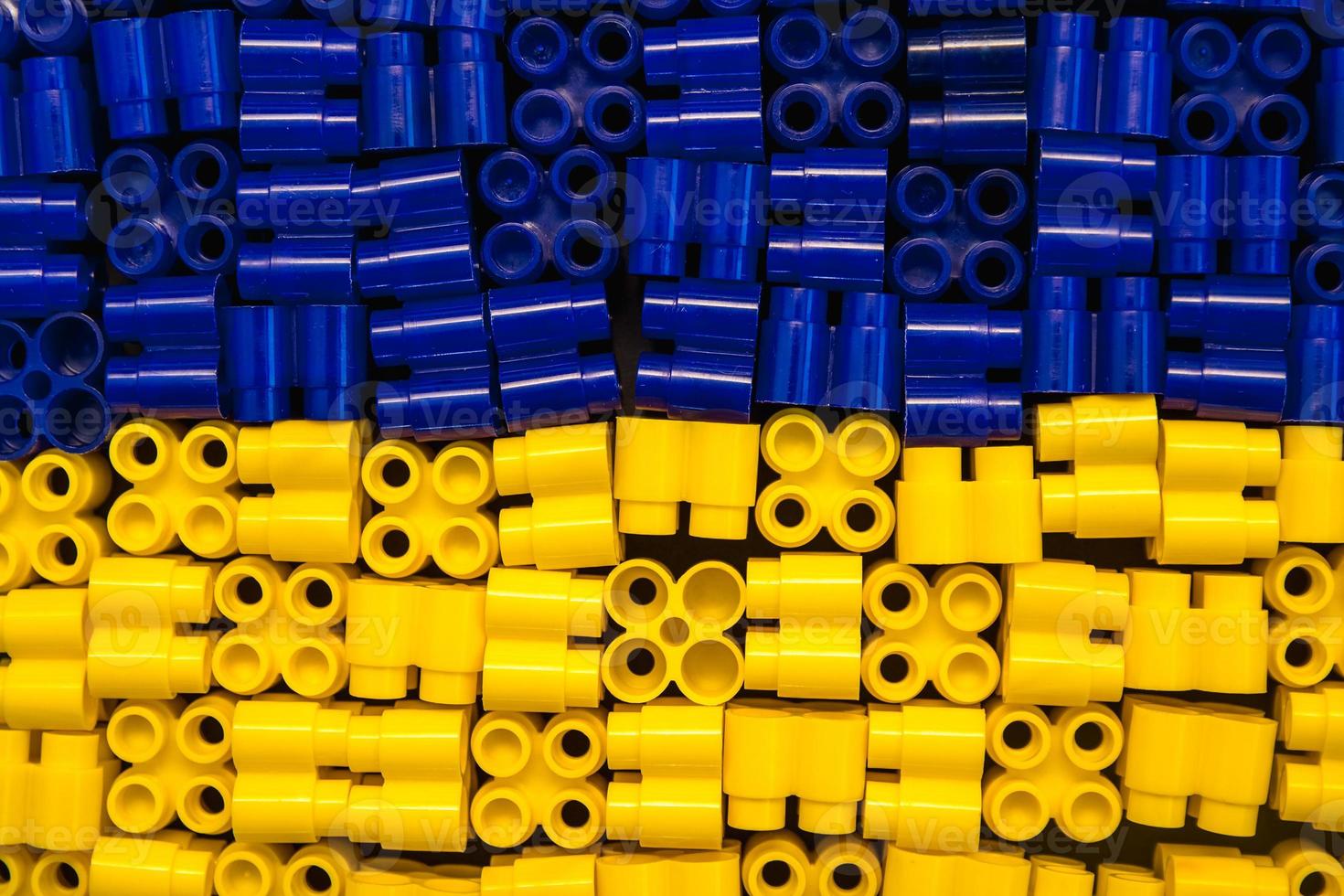 Plastic bricks are yellow and blue as a background texture photo
