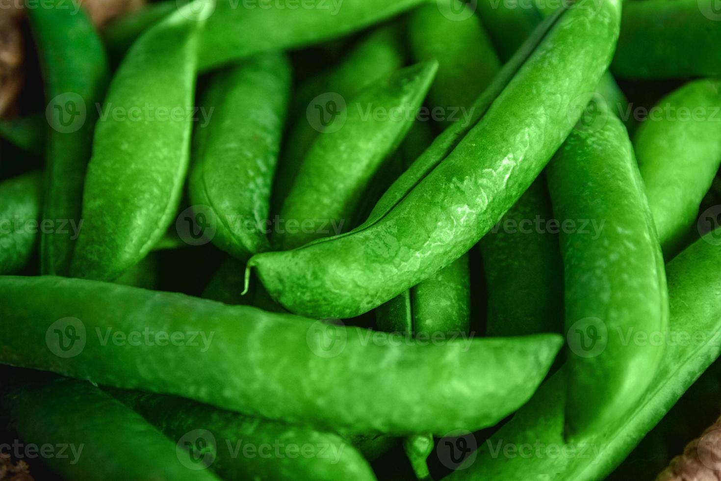 Cultivo de guisantes se encuentra en una cesta de mimbre redonda sobre un fondo de madera foto