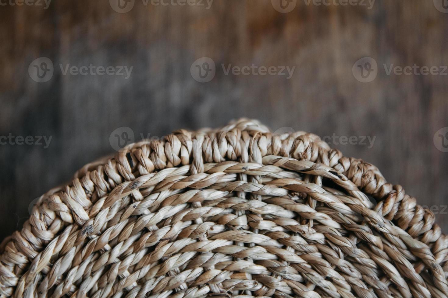 Element of a round wicker basket on a wooden background photo