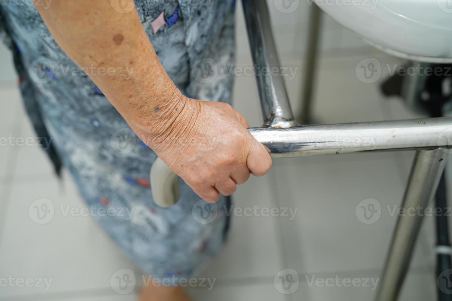 Mujer mayor asiática paciente uso inodoro baño manejar seguridad foto