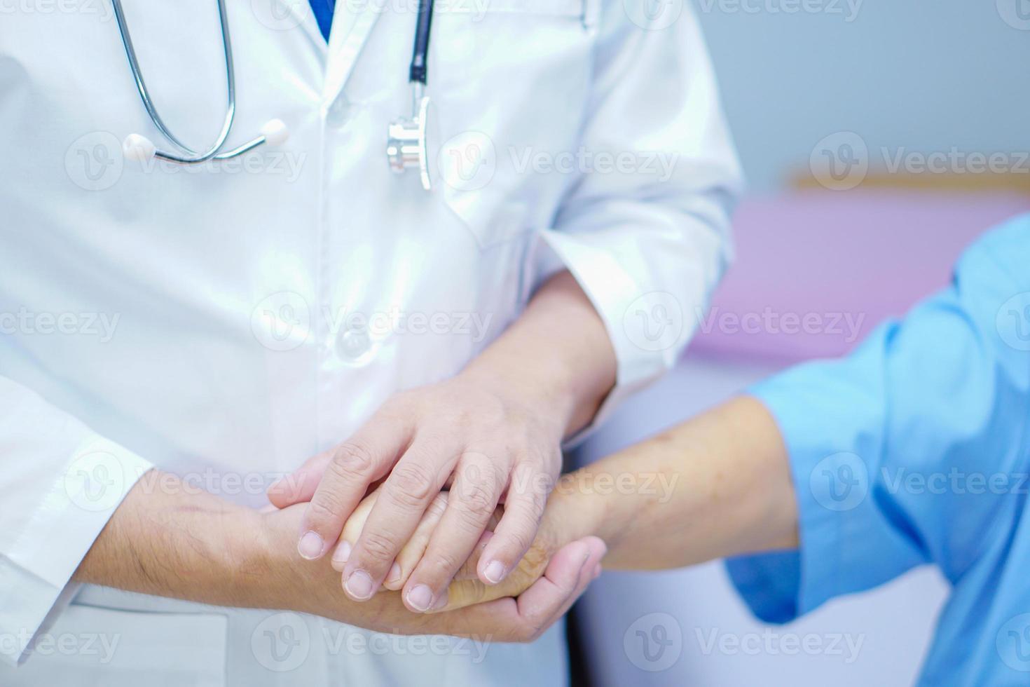 Doctor sosteniendo tocar las manos paciente mujer senior asiática con amor foto