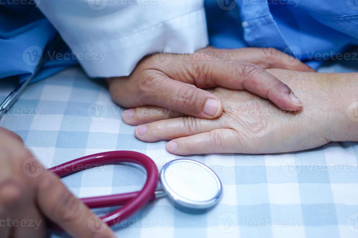 Doctor sosteniendo tocar las manos paciente mujer senior asiática con amor foto