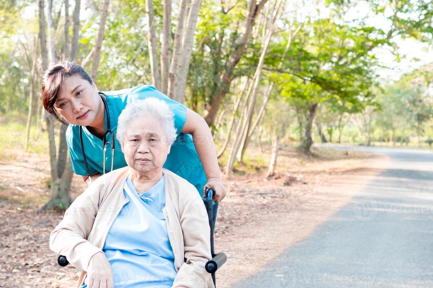 Help and care Asian senior woman use walker in park. photo