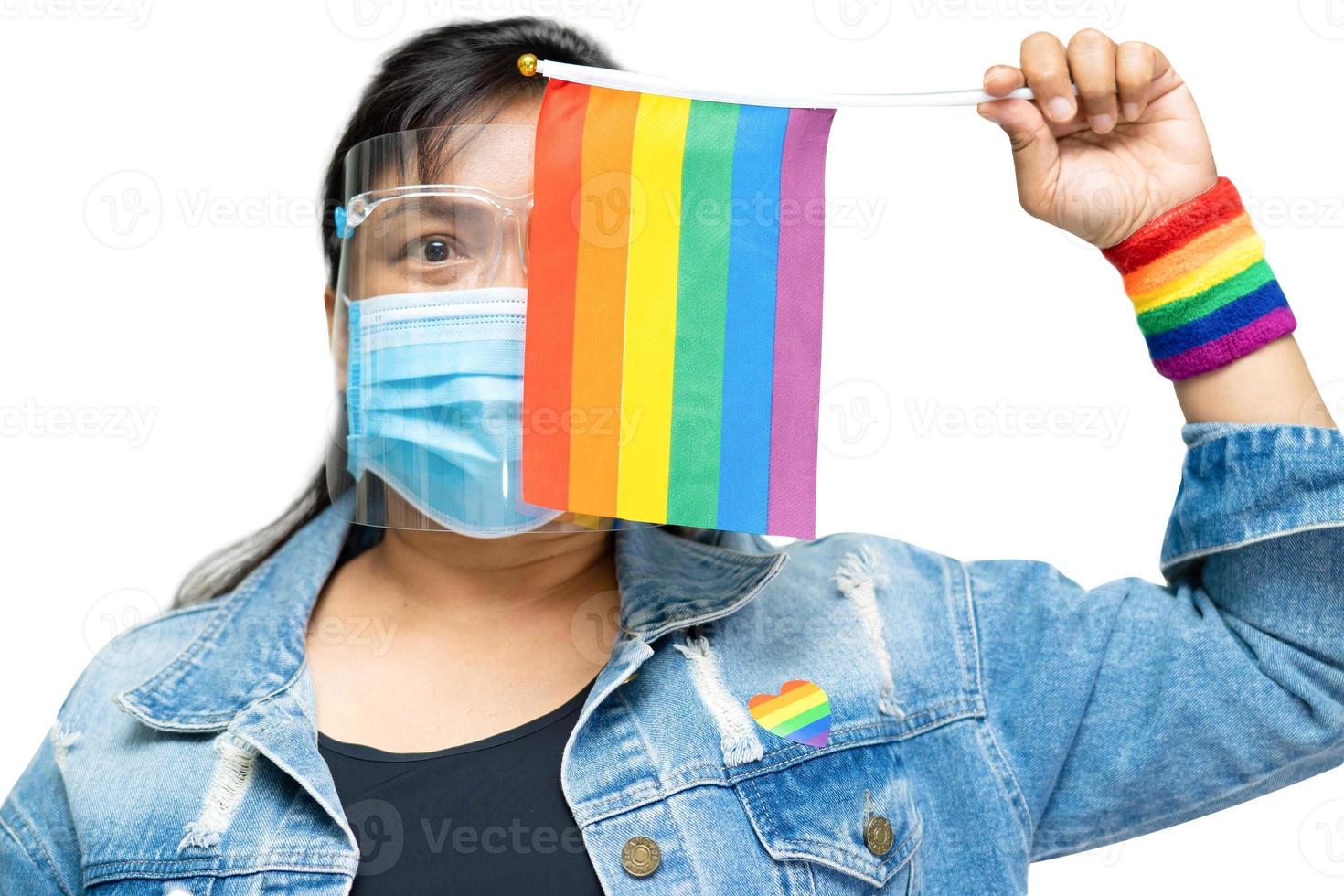 dama asiática sosteniendo la bandera de colores del arco iris, símbolo de lgbt foto