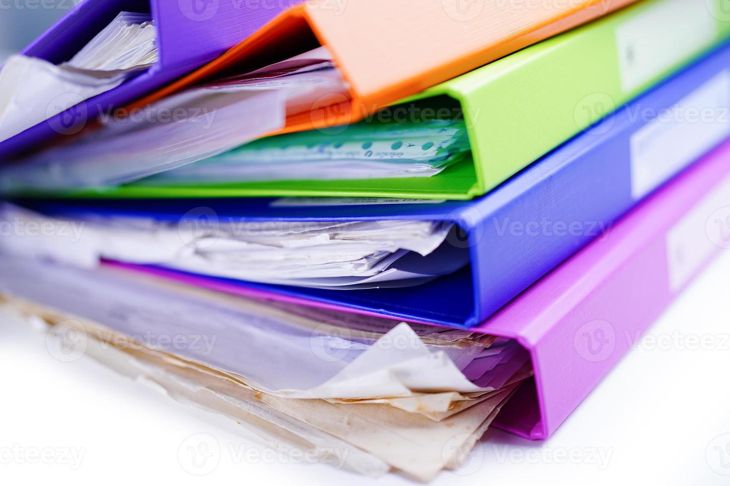 File Folder Binder stack of multi color on table in office. photo