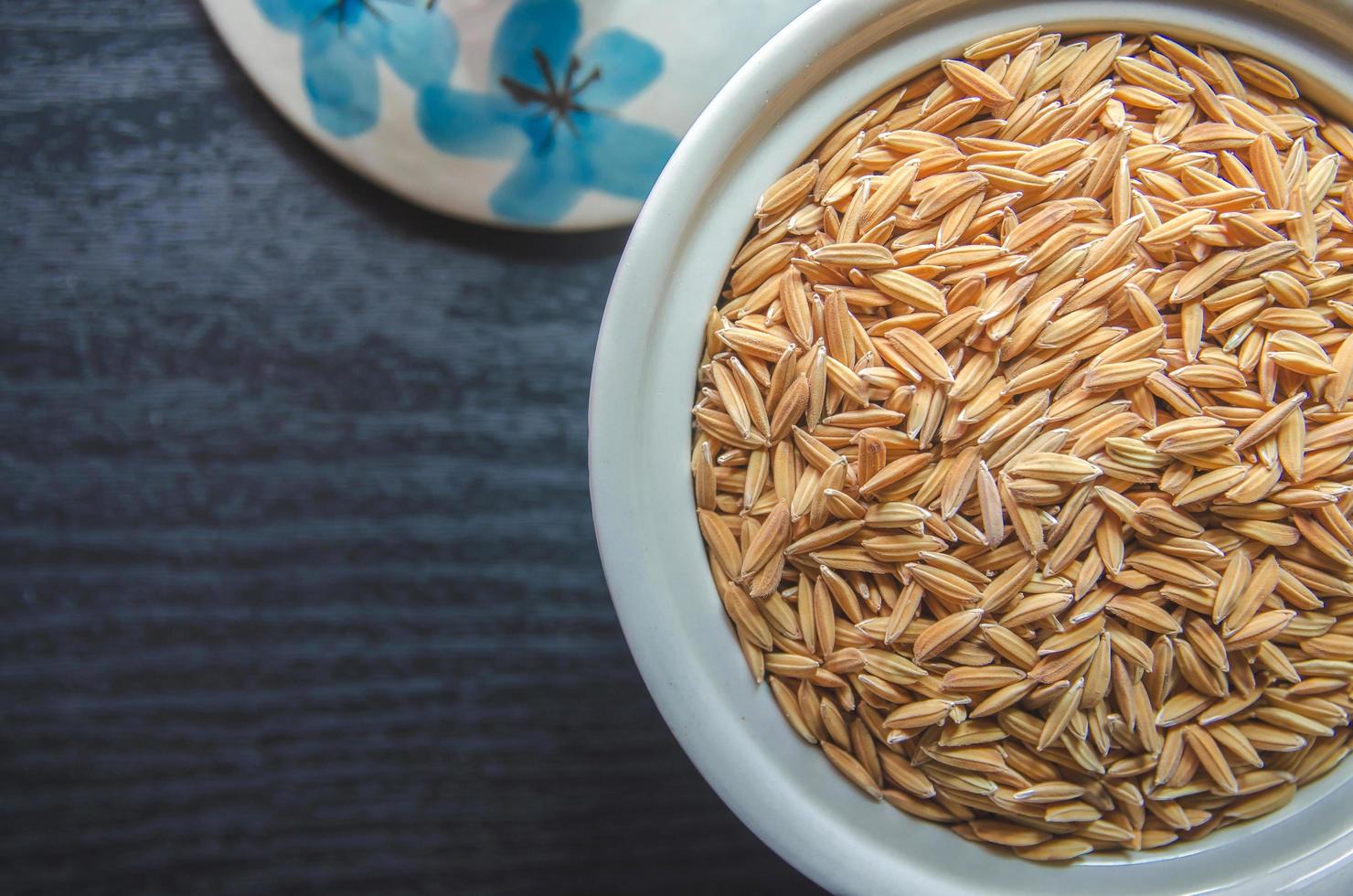 Fondo y papel tapiz por pila de arroz con cáscara y semillas de arroz. foto