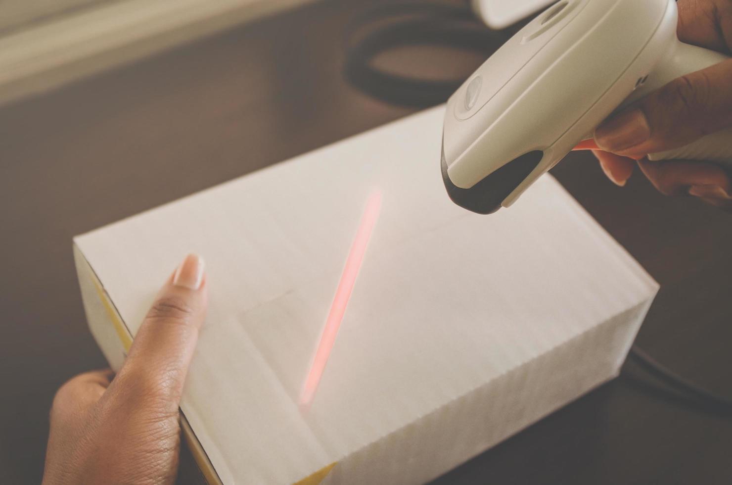 A human hand holding parcel with barcode reader for delivery. photo