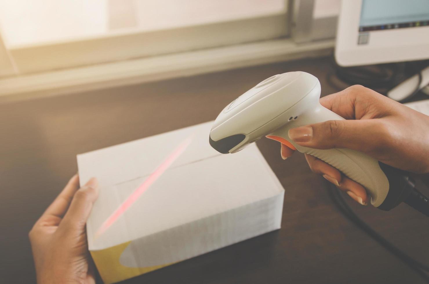 A human hand holding parcel with barcode reader for delivery. photo