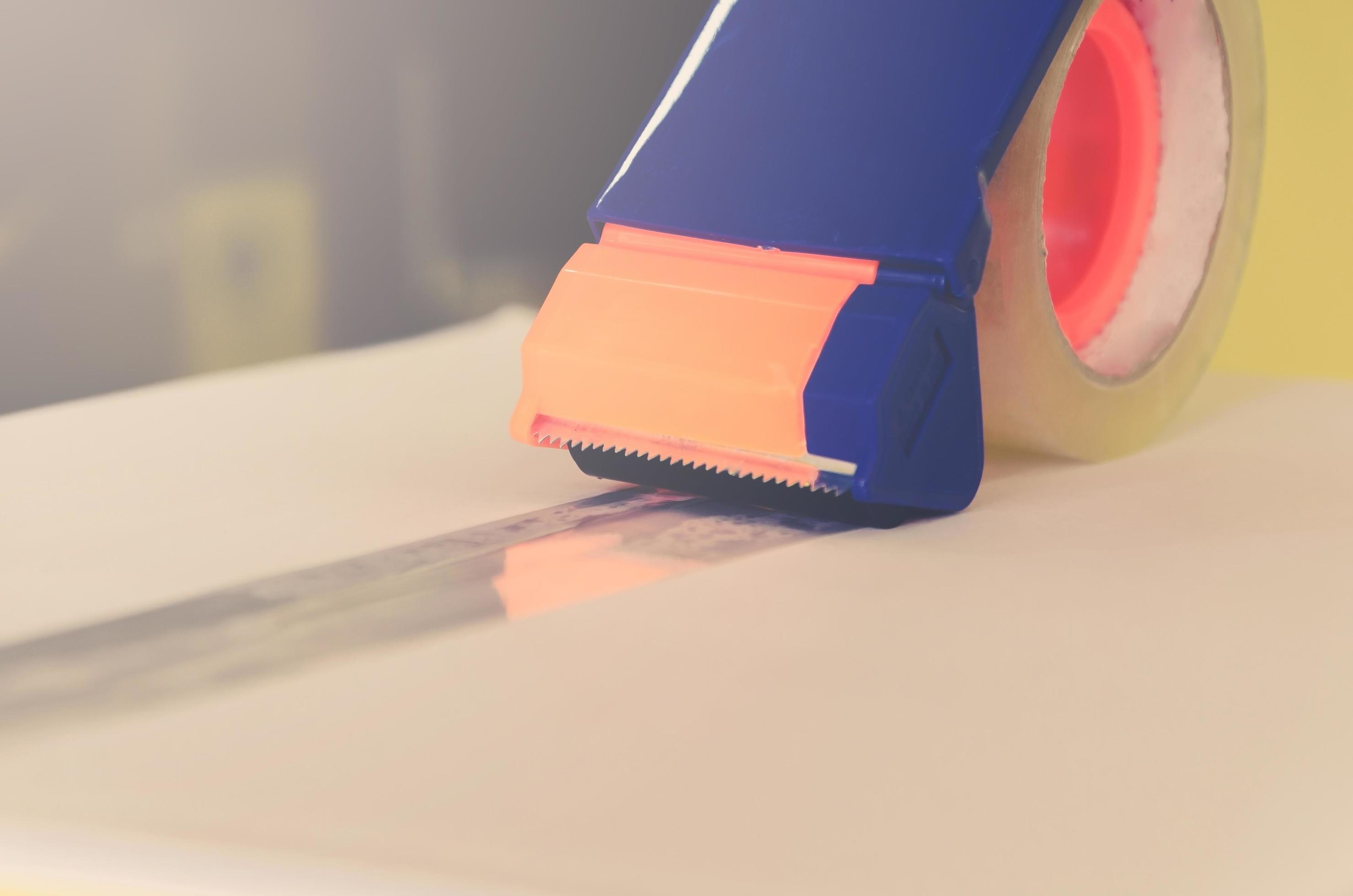 Preparing parcel for shipping with scissors and scotch tape cutter