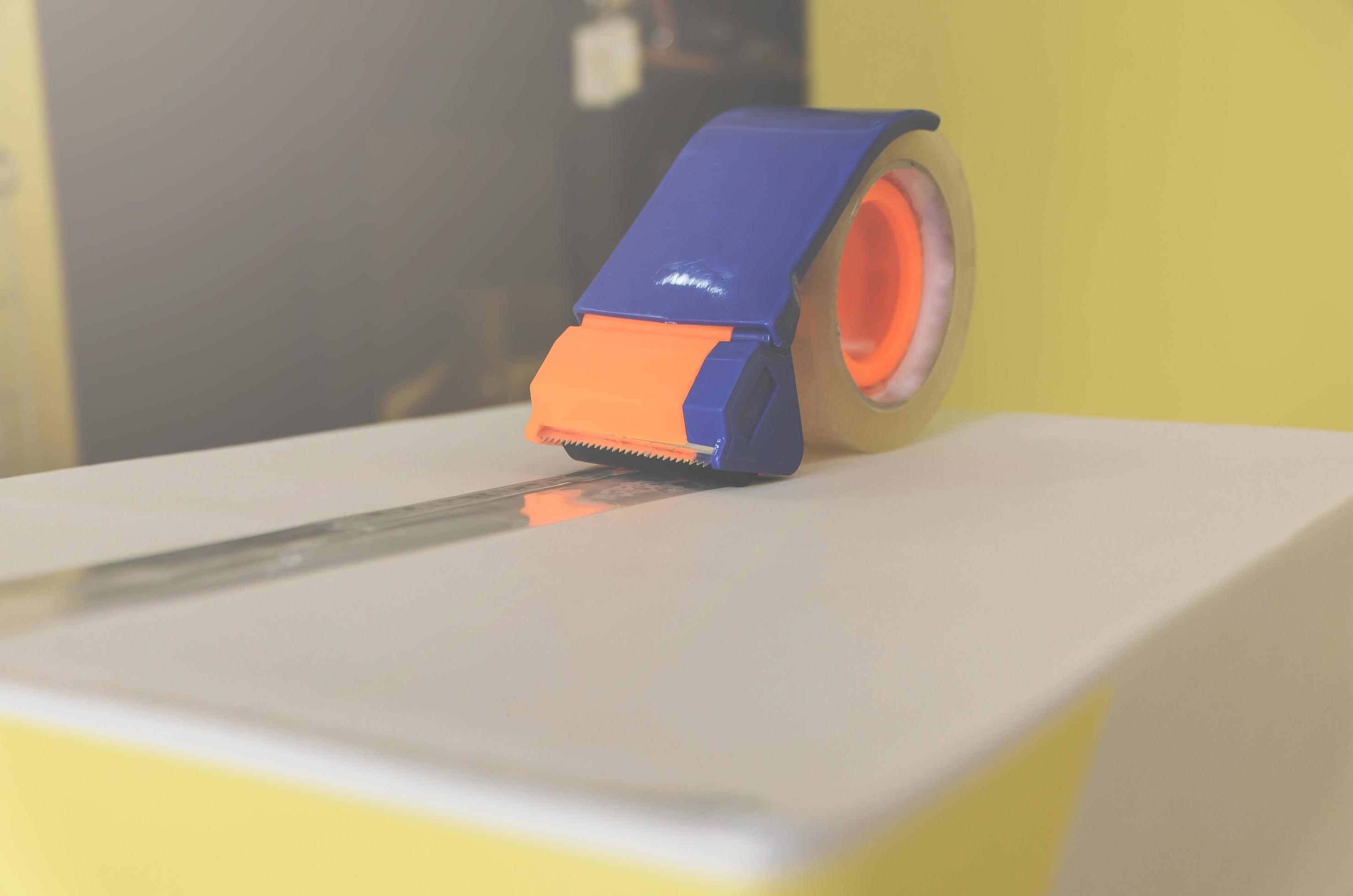 Preparing parcel for shipping with scissors and scotch tape cutter