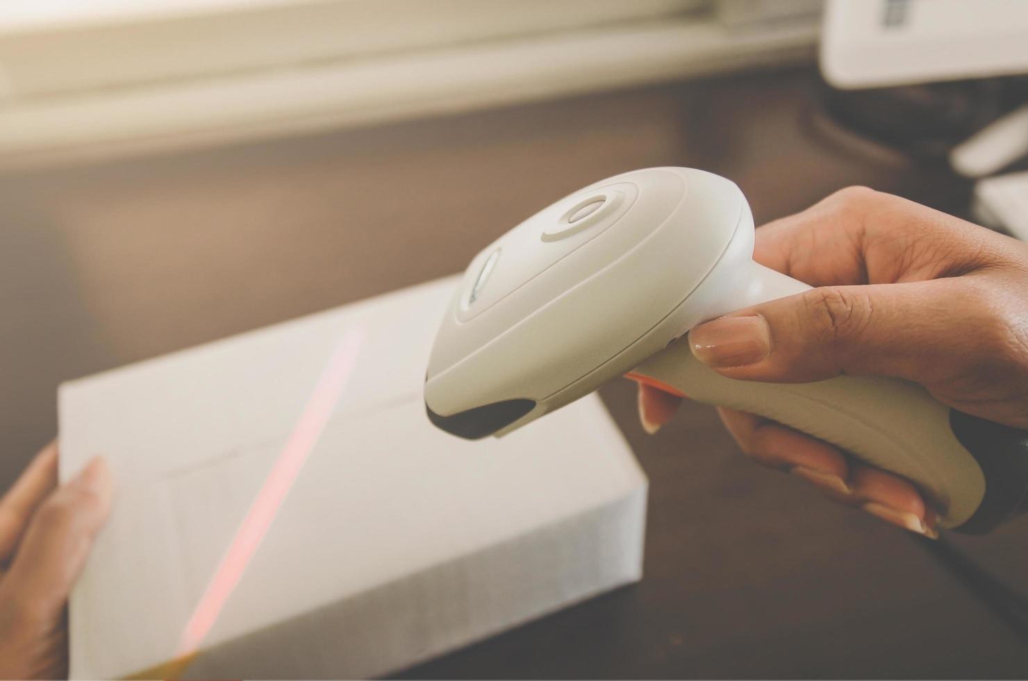 A human hand holding parcel with barcode reader for delivery. photo