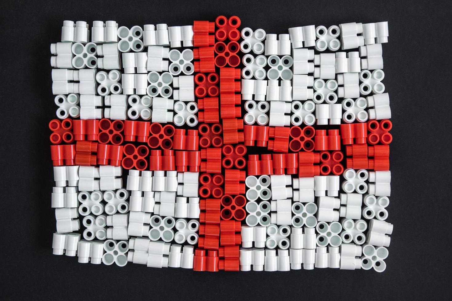 plastic bricks that form flag of England on background of black photo