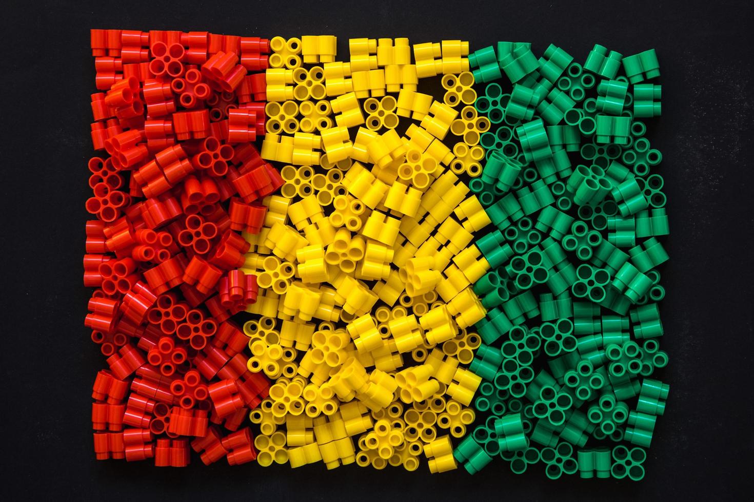 Plastic bricks of red, yellow and green on a black backgroun photo
